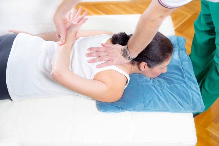 Woman receiving a chiropractic spinal adjustment treatment