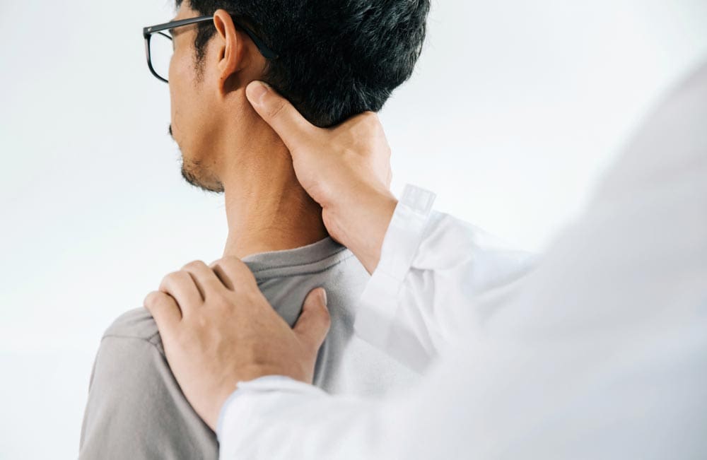 Chiropractor holding a man’s nape during neck assessment and treatment