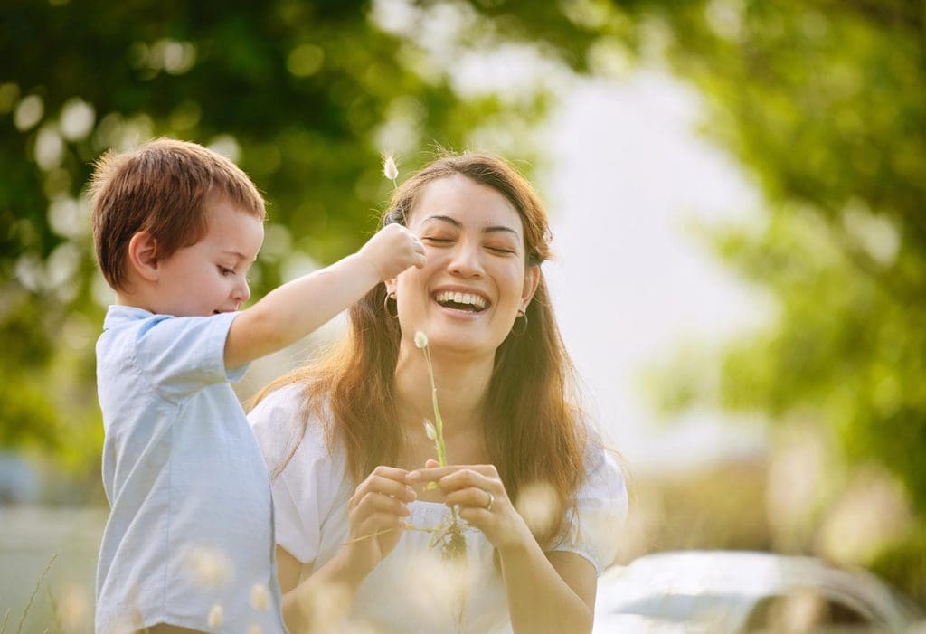 Mother hugging her son outdoors showing family love and wellbeing